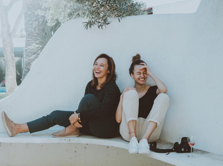 Two women sitting on a white bench. (Elle Hughes)