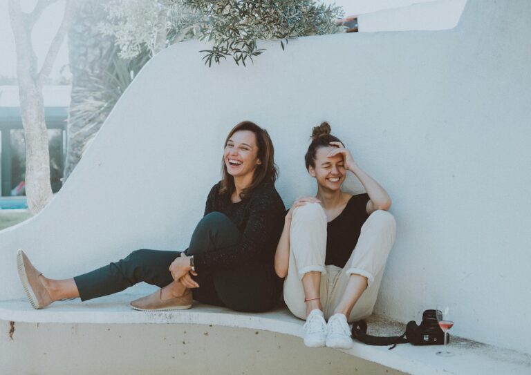 Two women sitting on a white bench. (Elle Hughes)