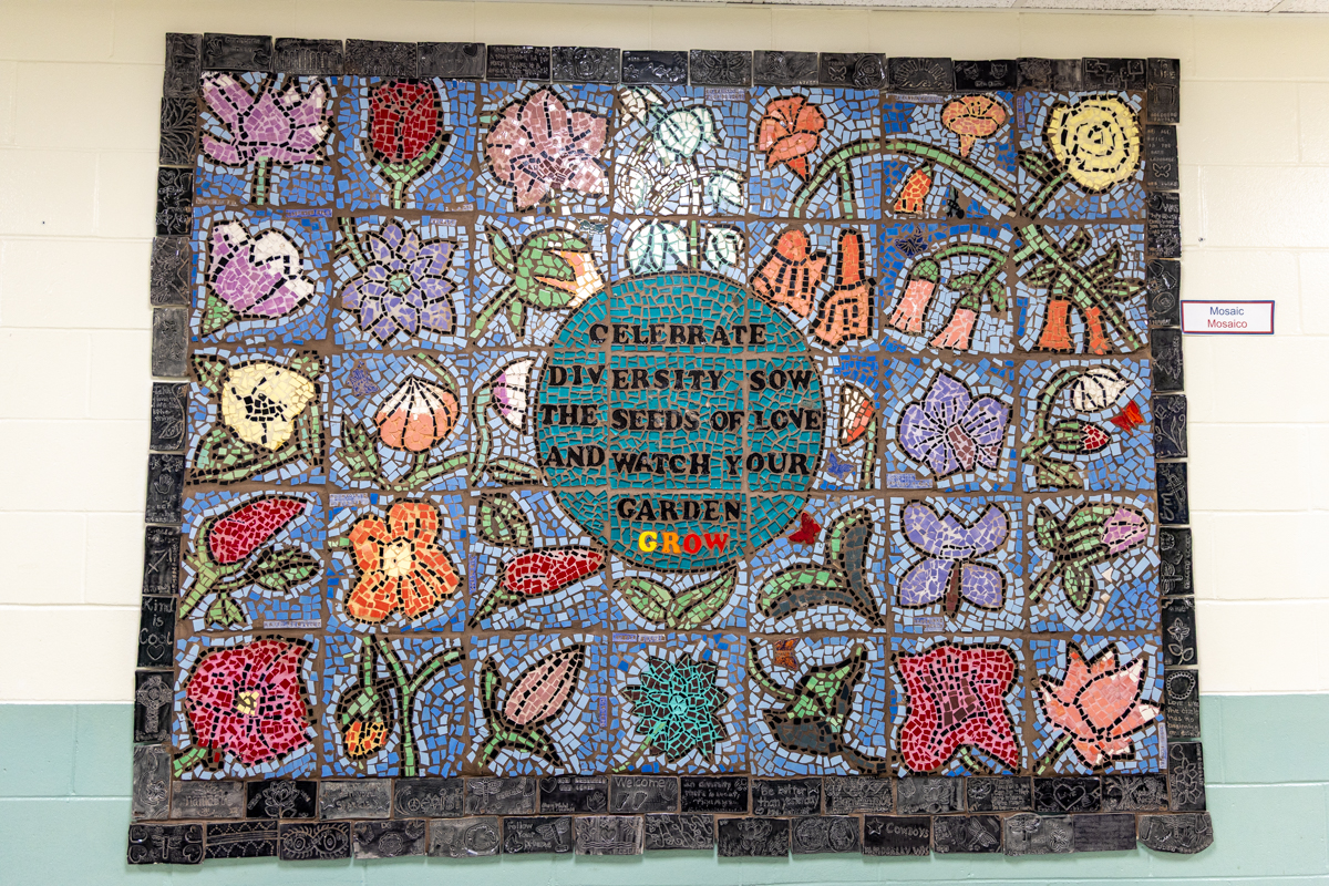 a mural reads CELEBRATE DIVERSITY SOW THE SEEDS OF LOVE AND WATCH YOUR GARDEN GROW