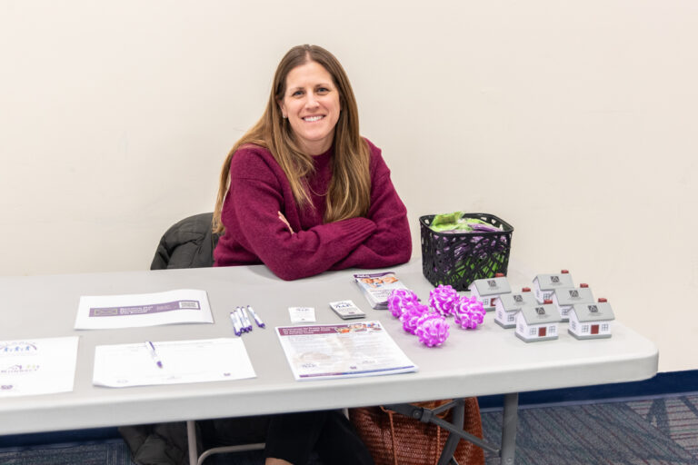 Cecelia Gaines sitting behind the information table at the resource fair