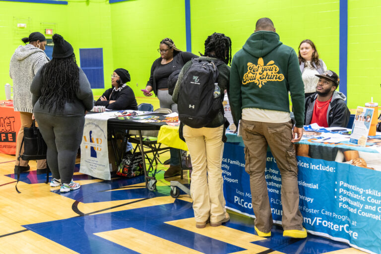 Attendees of the resource fair speak with vendors at their tables during the resource fair