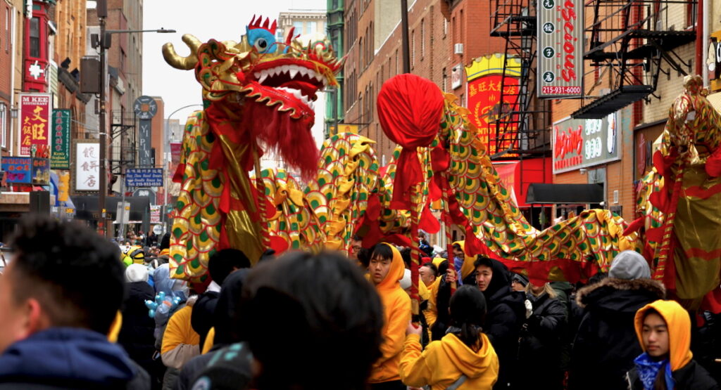 2025 02 02-c sharber-philadelphia-lunar new year People holding up a long flying dragon while marching down the street as part of the Lunar New Year parade in Philadelphia's Chinatown.