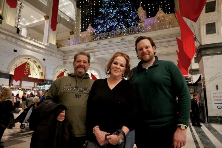 Family poses for photo at the Christmas light show inside the Wanamaker Building