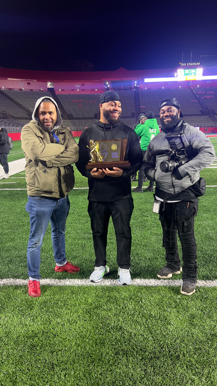 Bill Belton holding his state championship plaque. Theron Louis (on the right), a cinemetographer at WHYY, nominated Belton for the Good Souls Project.