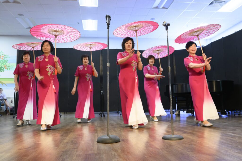 senior-center-asians-philadelphia Asian women dance inside while holding traditional umbrellas