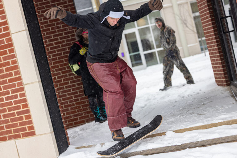 A snowboarder to catches air outside Vessel Coffee Collection in Philadelphia’s Fishtown neighborhood on Jan. 25, 2026. (Kimberly Paynter/WHYY)