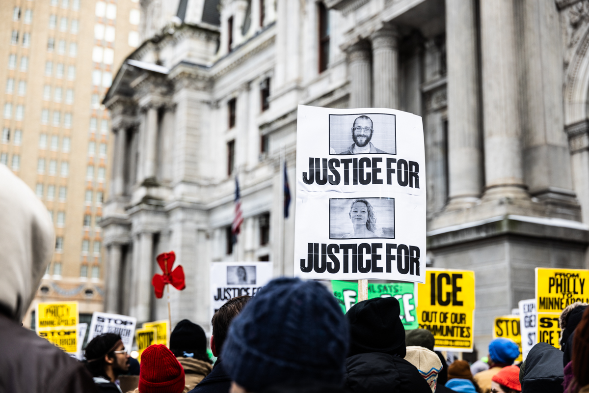a sign reads JUSTICE FOR JUSTICE FOR with photos of Renee Good and Alex Pretti