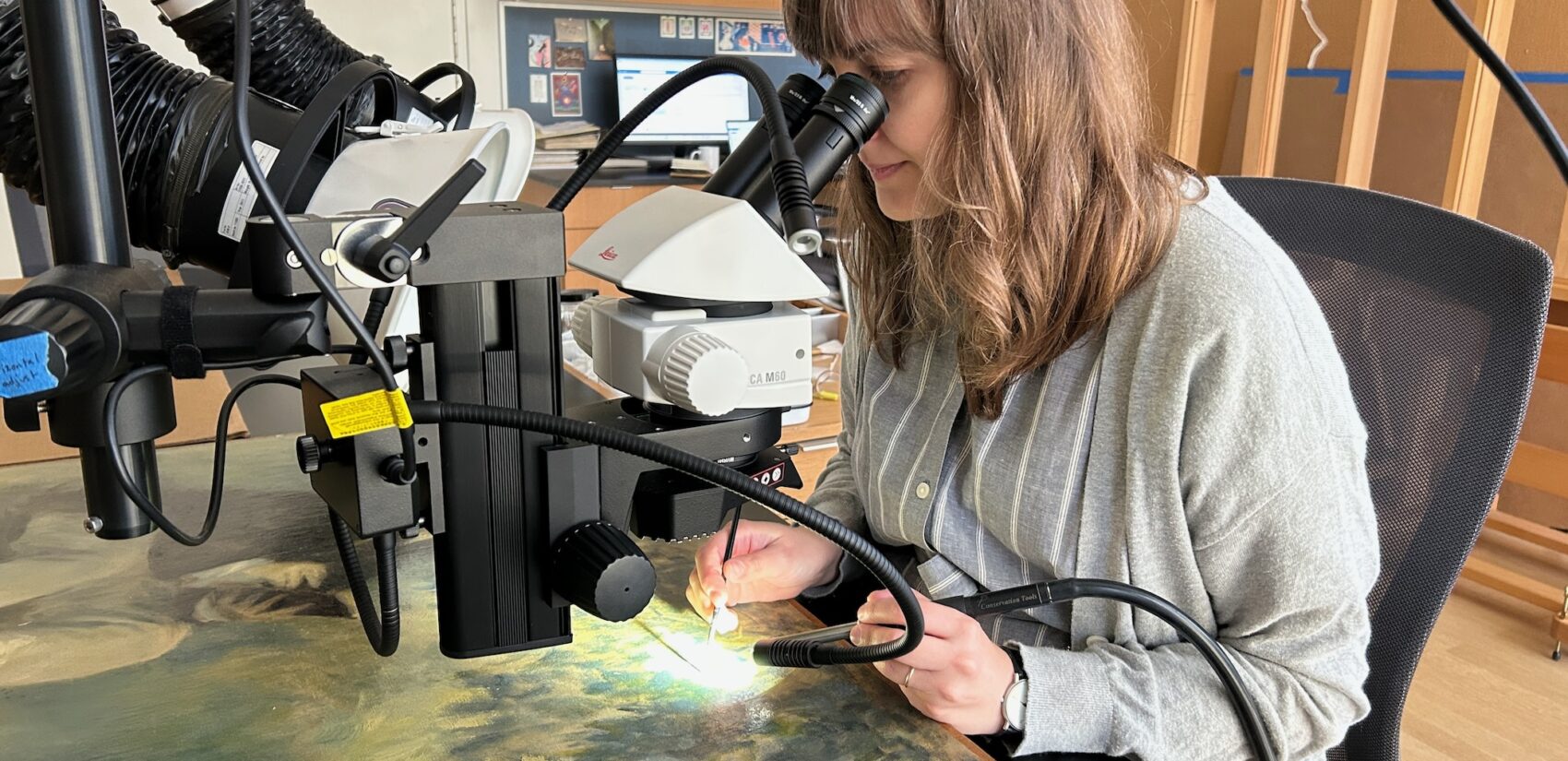 Christie Romano, associate conservator of paintings at The Barnes Foundation, looks at a painting through a microscope