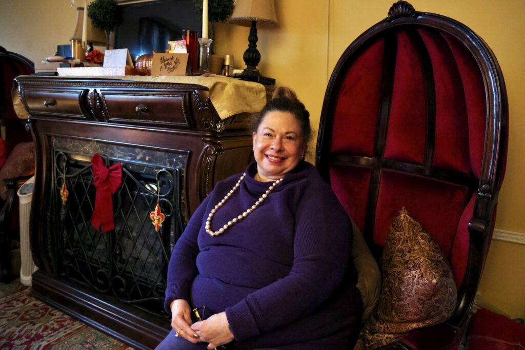 Jane Berryman poses for a photo sitting in her living room.