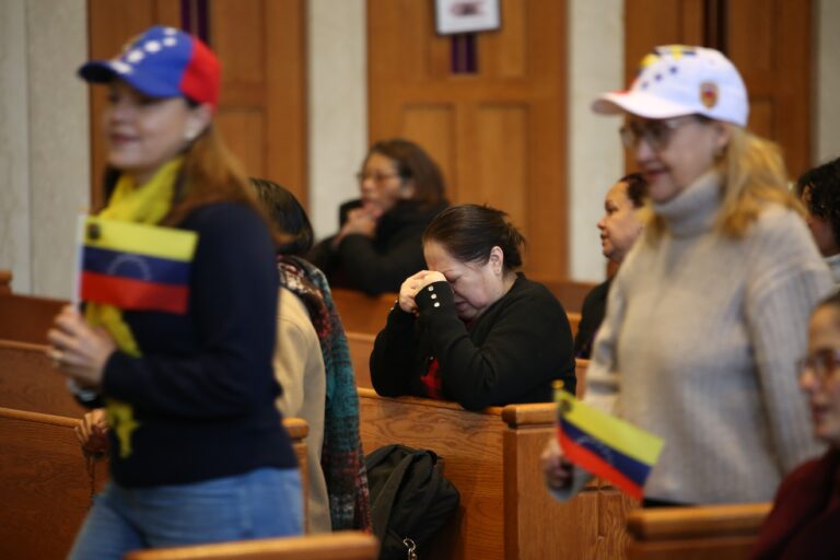 People hold Venezuelan flags at the Cathedral Basilica of Saints Peter and Paul