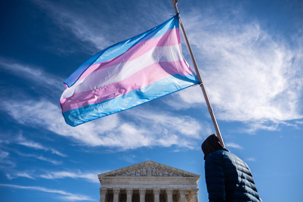Supreme Court Transgender Athletes Protesters wave transgender pride flags outside the Supreme Court as it hears arguments over state laws barring transgender girls and women from playing on school athletic teams, Tuesday, Jan. 13, 2026, in Washington. (AP Photo/Julia Demaree Nikhinson)