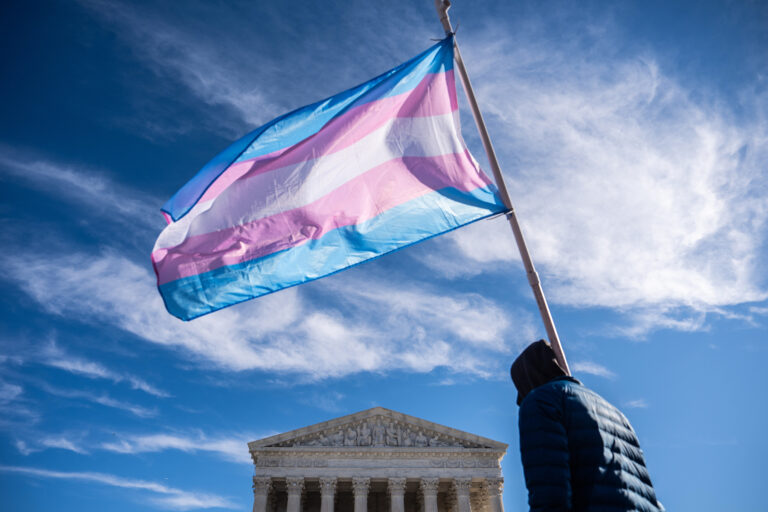 Protesters wave transgender pride flags outside the Supreme Court as it hears arguments over state laws barring transgender girls and women from playing on school athletic teams, Tuesday, Jan. 13, 2026, in Washington. (AP Photo/Julia Demaree Nikhinson)