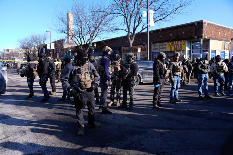 Federal agents stand near the site of a shooting
