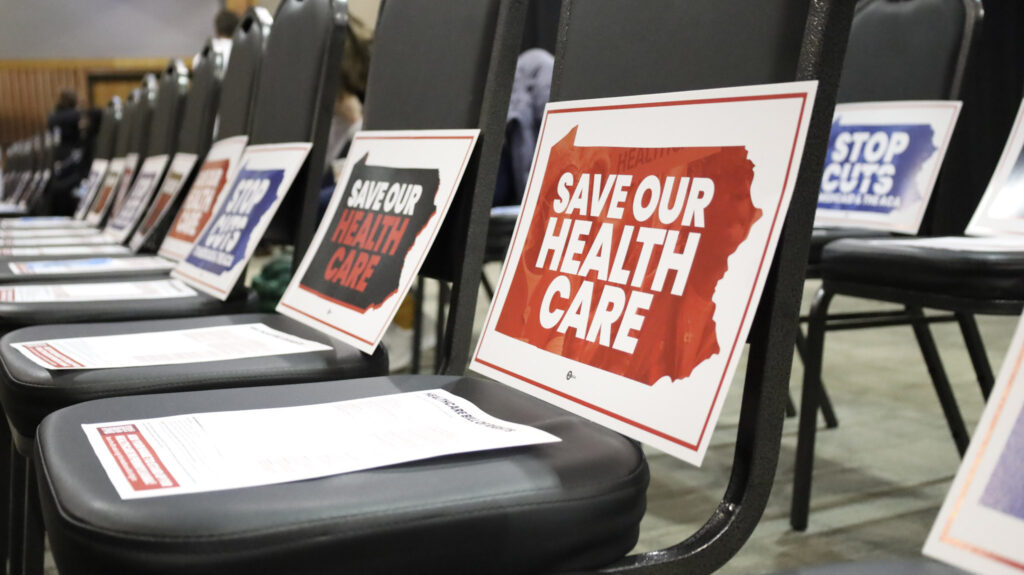 Signs placed on chairs read "Save Our Health Care"