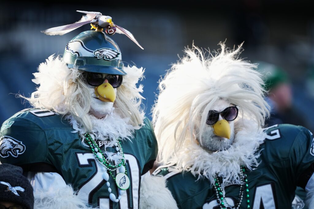 Commanders Eagles Football Two Eagles fans at the football stadium dressed in Eagle costumes from head to toe, and wearing jerseys
