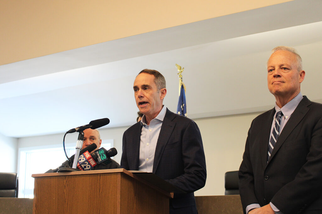 ecra-1 State Sen. Steve Santarsiero, left, and state Rep. Perry Warren, right, stand at a podium