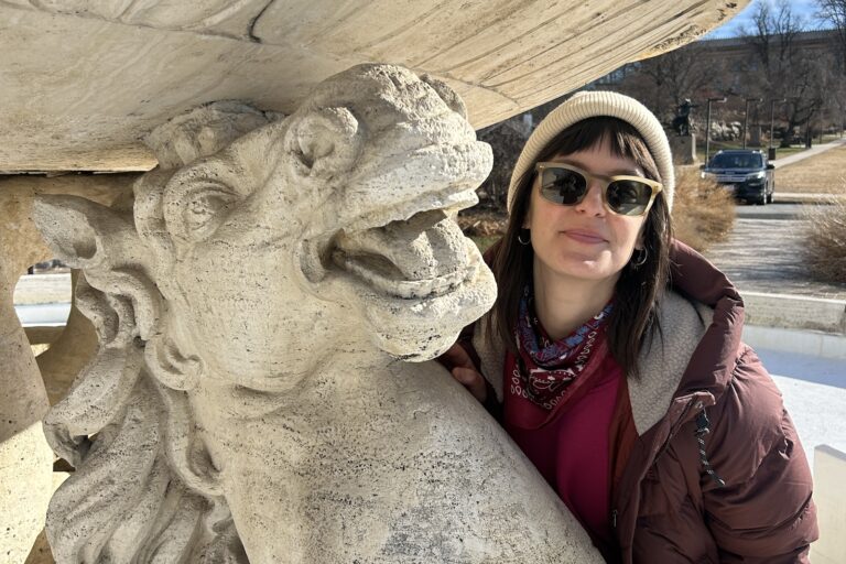 Emily Robb posing for a photo next to a statue of a horse