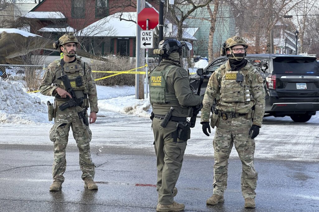 Immigration Enforcement Minnesota Federal law enforcement officers stand near a roadblock at Portland Avenue and East 32nd Street