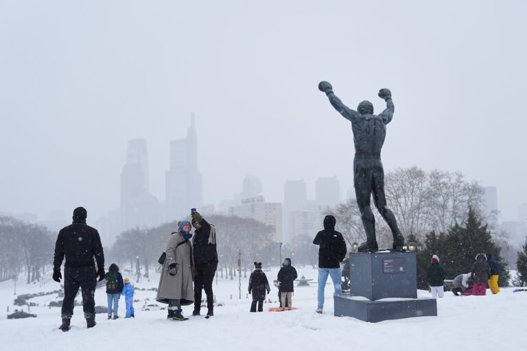 People gather at Philadelphia Art Museum steps by the Rocky statue during a winter storm in Philadelphia, Sunday, Jan. 25, 2026.