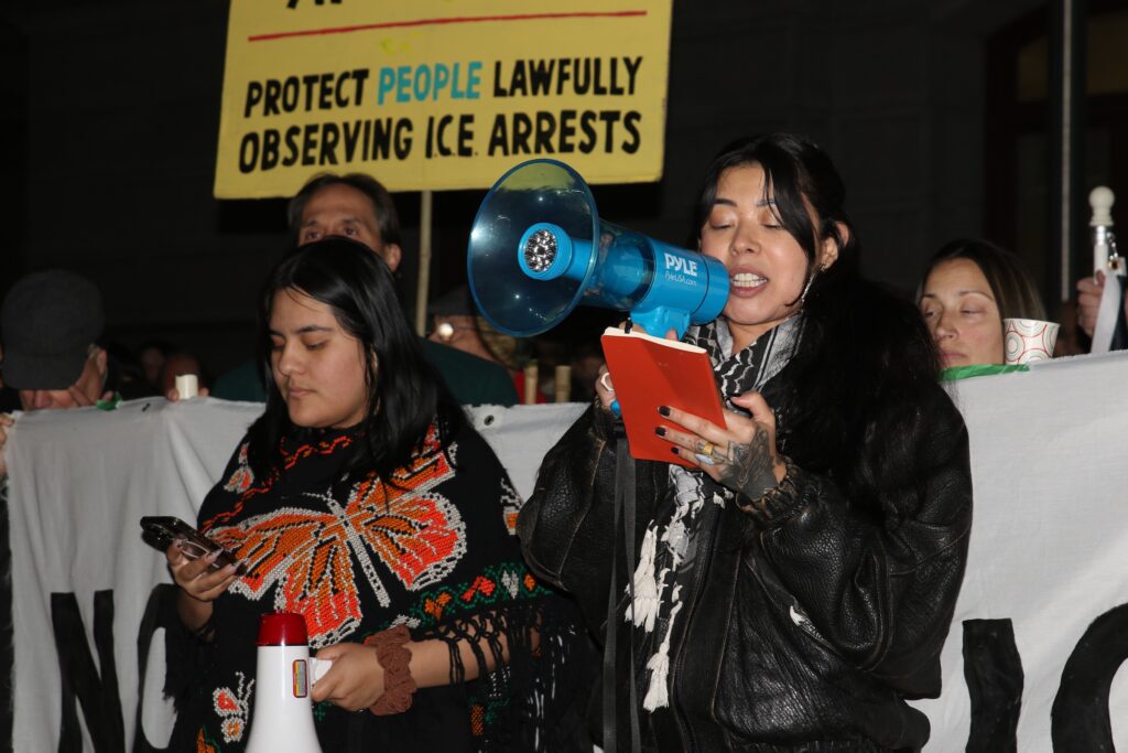 A woman speaks into a megaphone at a protest in Philadelphia