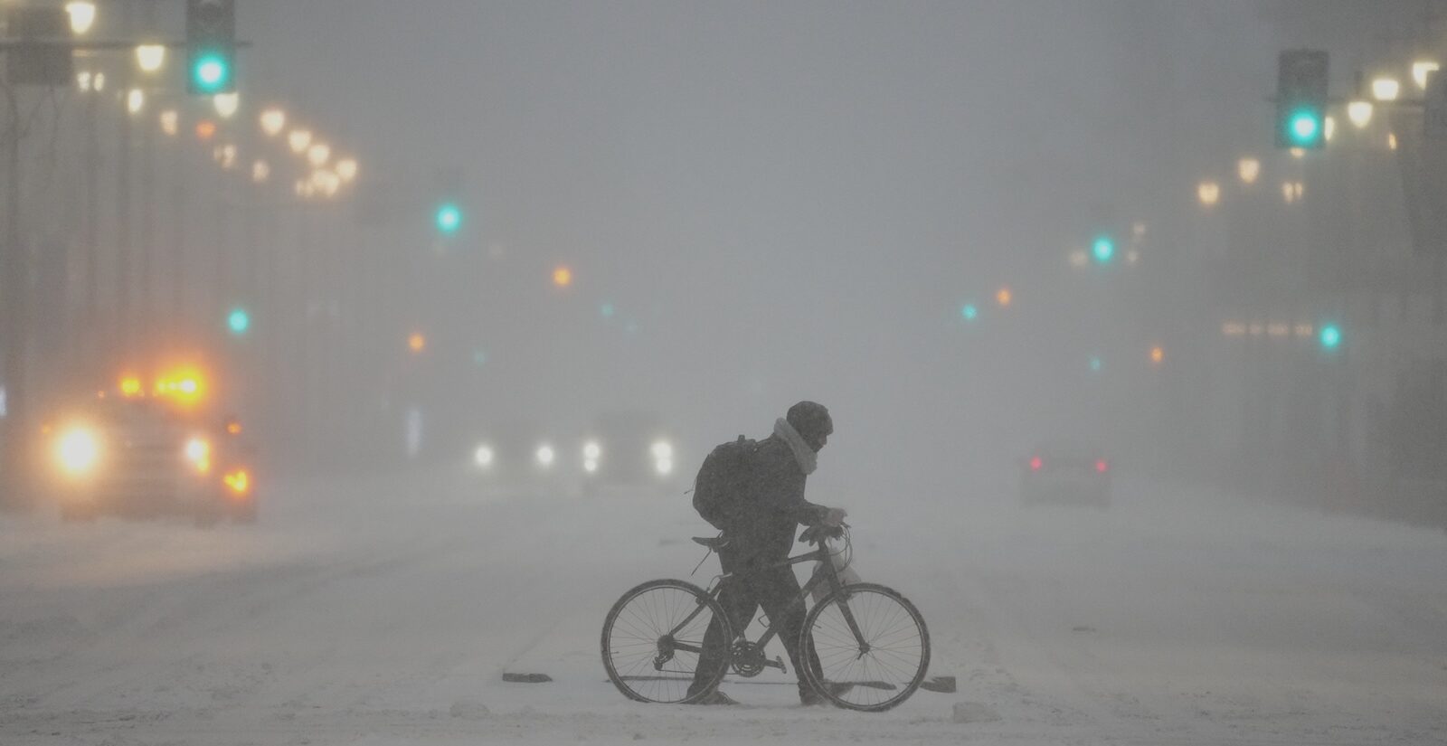 A person pushes a bicycle during a winter storm in Philadelphia, Sunday, Jan. 25, 2026.