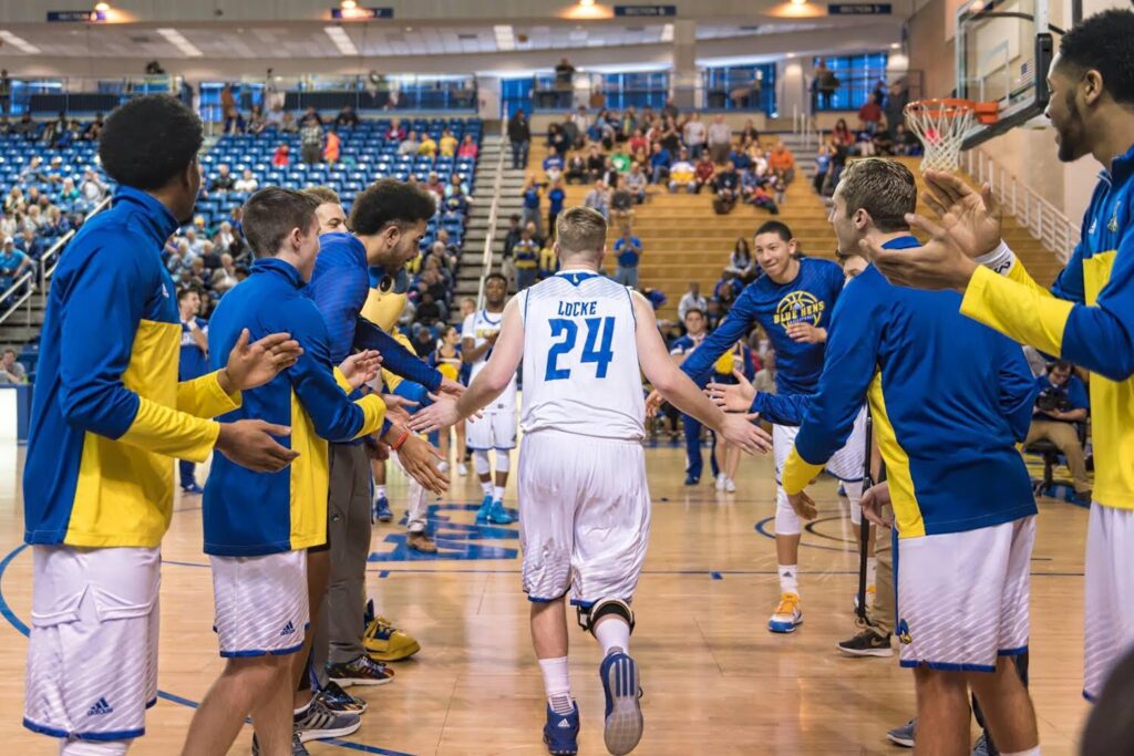 Sean Locke receives high fives from teammates before a basketball game