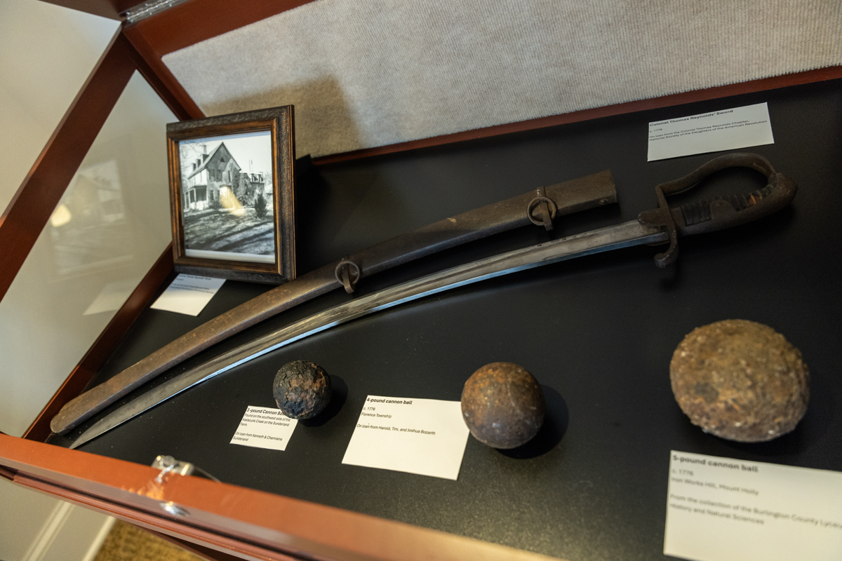 American Revolution artifacts like canon balls and a sword on display in the Burlington County Joins the Revolution exhibit in the Warden’s House Gallery in Mt. Holly, N.J. (Kimberly Paynter/WHYY)