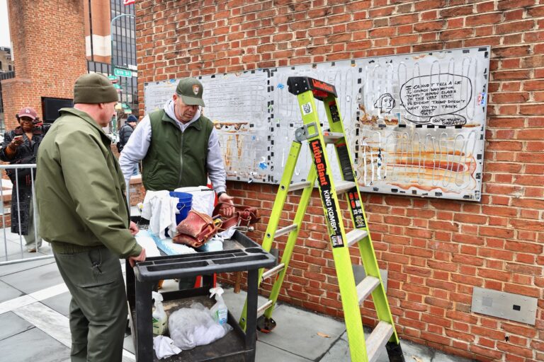 Workers are hanging the panels back up on the wall