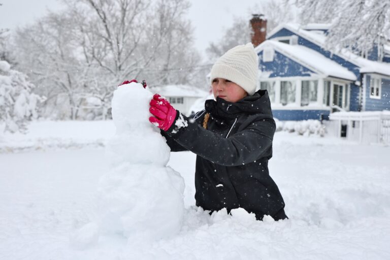 Bella Usle building a snowman during a massive snowstorm