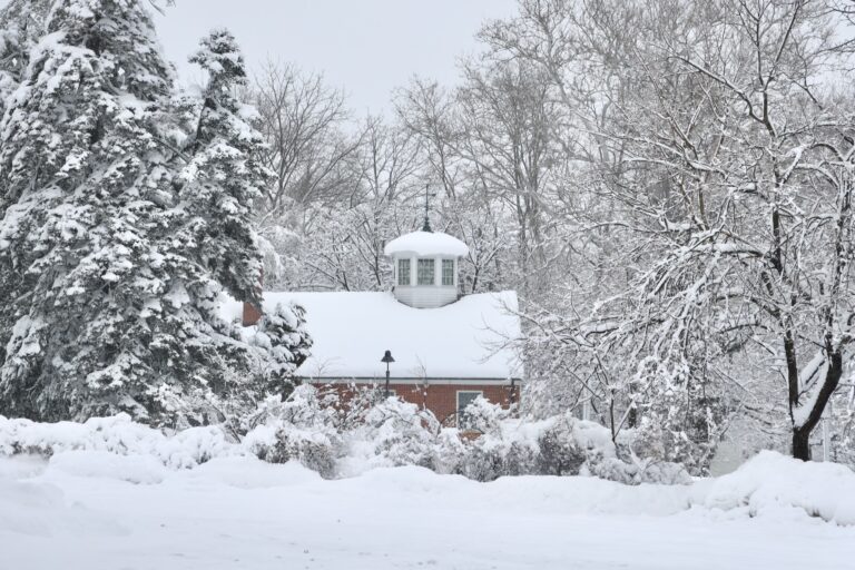 Snow blankets the yard, trees, and roof of a school building in Moorestown, New Jersey