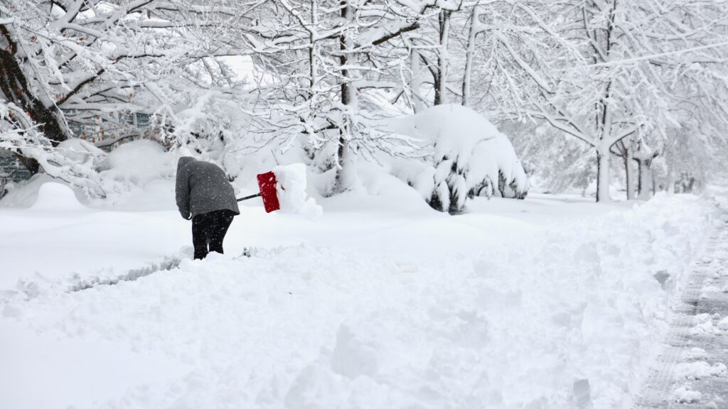 2026 02 23-e lee-moorestown nj-blizzard aftermath red shovel A person is shoveling a sidewalk after massive snowstorm in Moorestown, New Jersey