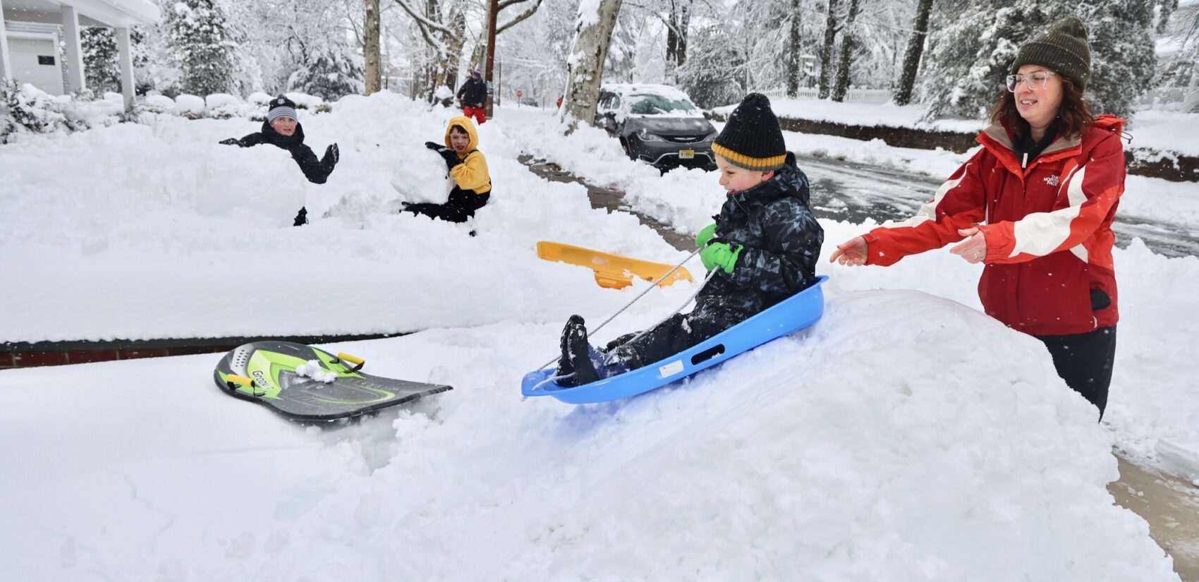 A child is being pushed down a small hill on a sled after huge snowfall in Moorestown, New Jersey
