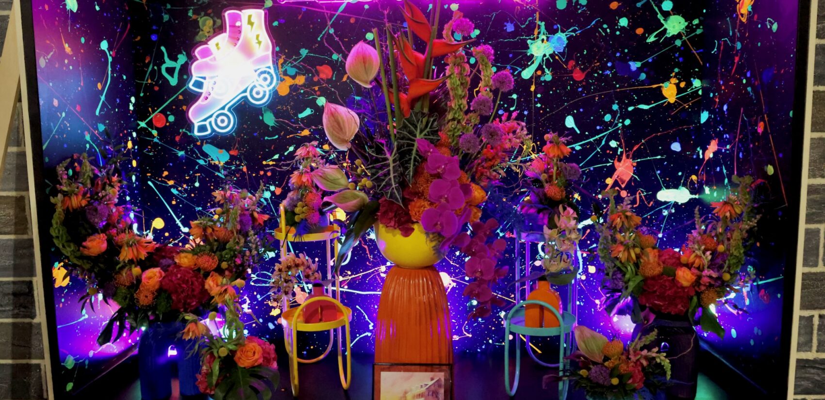 a neon sign says FLOWER with flowers in front of it