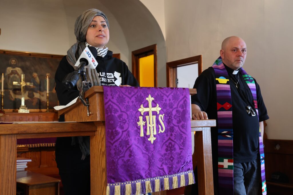 Asma Elhuni speaking at a podium