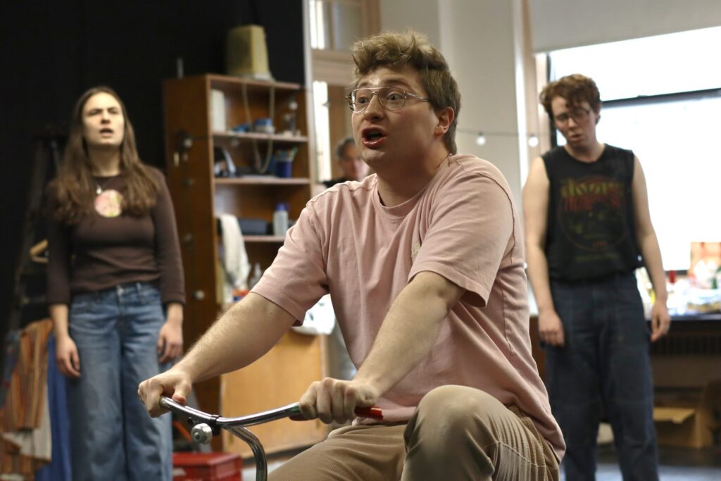 Herschel-on-trcycle-in-Gemini-rehearsals-04-scaled Jeff Pfieffer as Herschel, Tommy Sullivan-Lovett and Eliza Waterman rehearsing