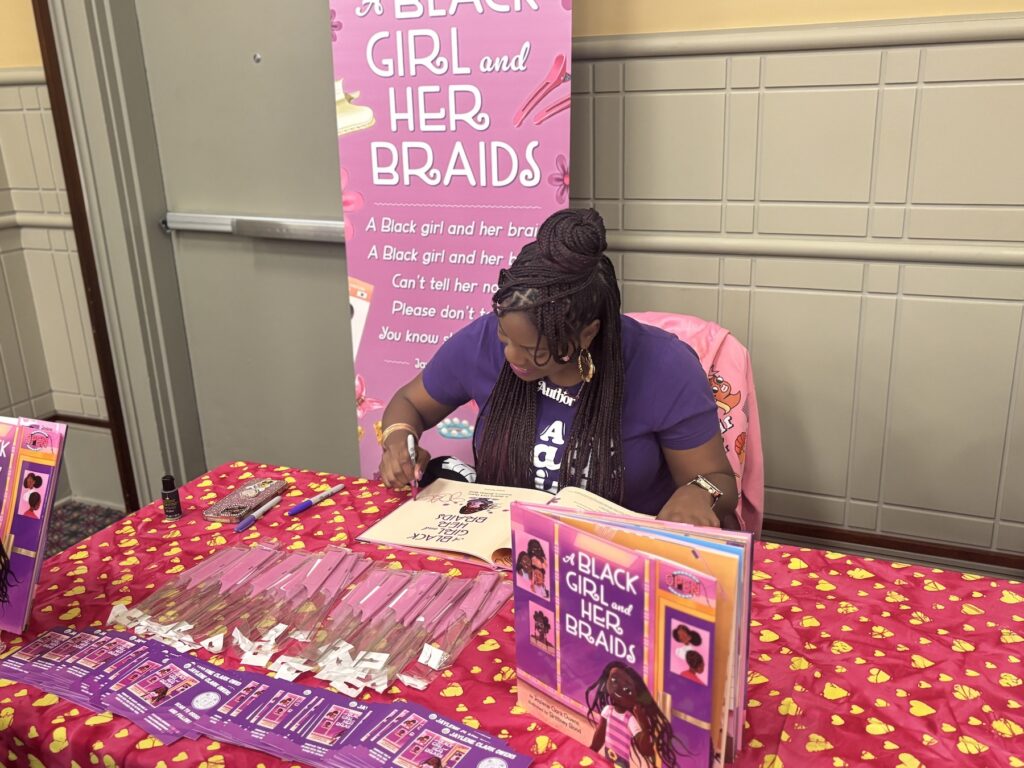 Author Jaylene Clark Owens signs a copy of her book