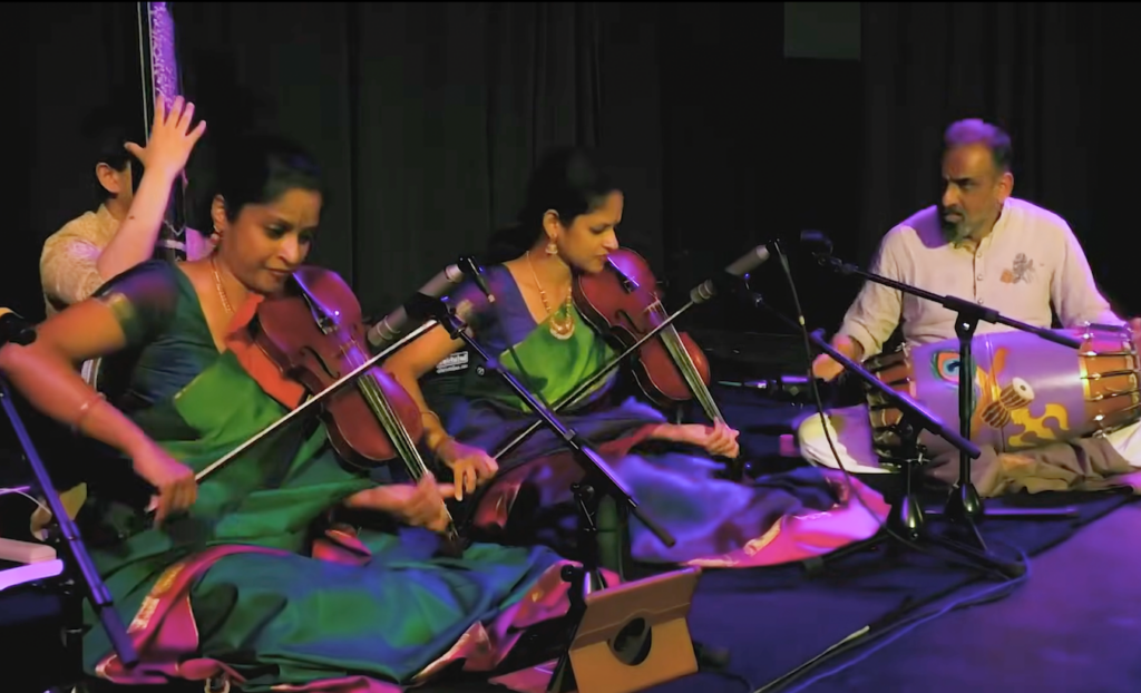 akkarai-sisters-rotunda-fire-museum-2026-02-27-2 The Akkarai Sisters sitting on stage performing during a concert