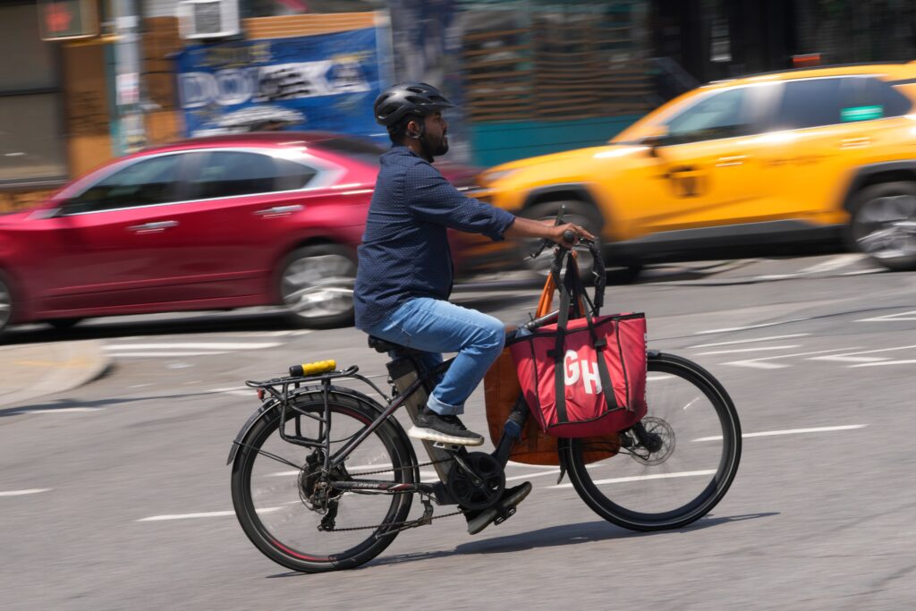 e-bike-file-ap A delivery worker rides a motorized bicycle