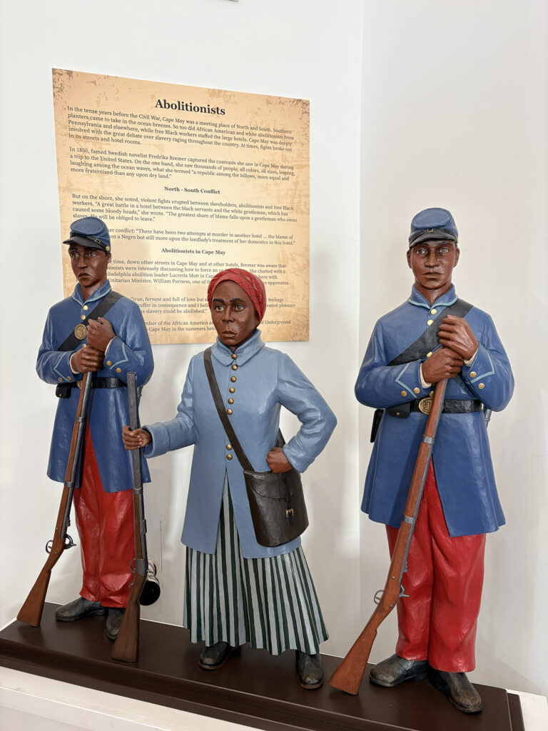 Figures of Black abolitionists, including Harriet Tubman, stand at a museum