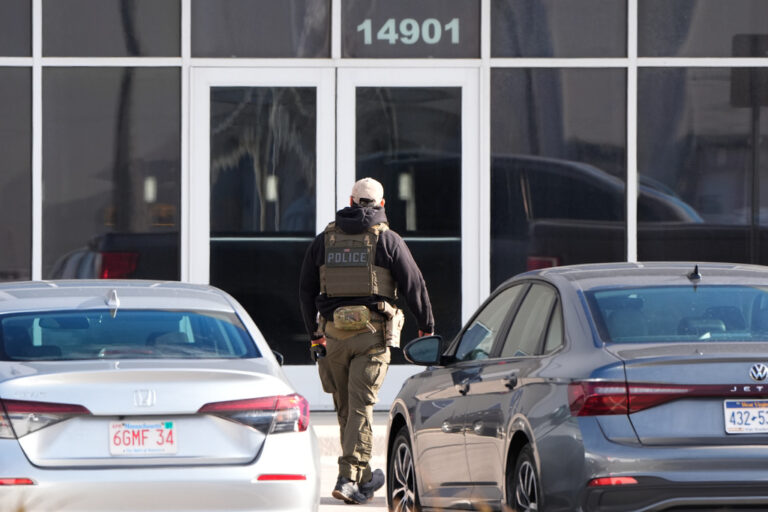 An ICE agent stands outside a warehouse