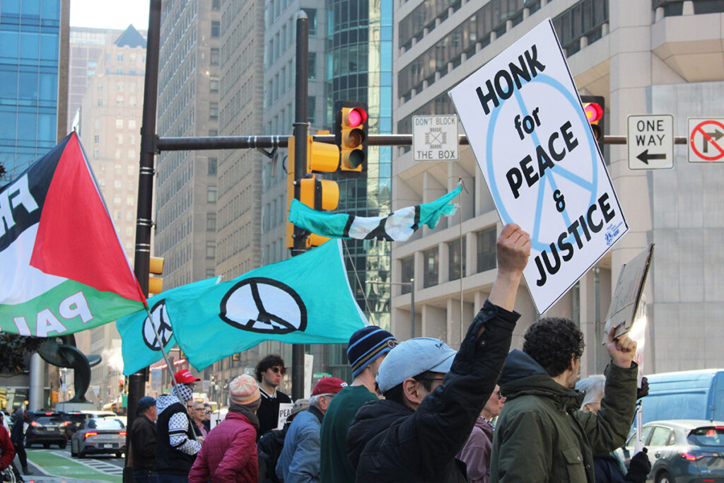 People hold signs in Philadelphia protesting war in Iran