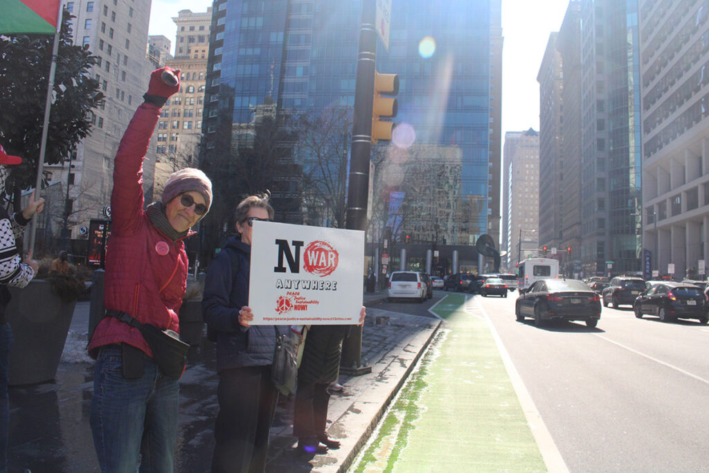 People hold signs in Philadelphia protesting war in Iran
