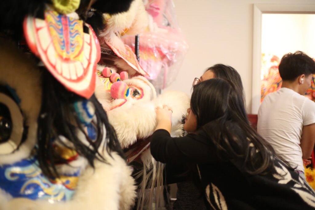 lunar-new-year-philadelphia-2026-7 two people looking at fabric lion heads