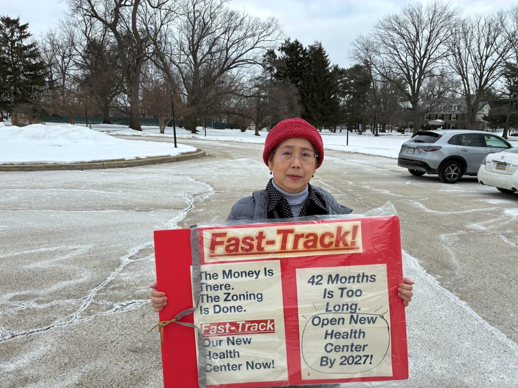 northeast-philadelphia-new-health-center-2026-1 Mingchu Pearl Huynh holds a sign about fast-tracking opening a new health center