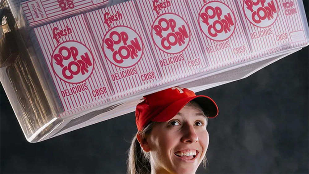 Same the Popcorn Girl, who sells popcorn at Philadelphia Phillies games, balances boxes of popcorn on her head