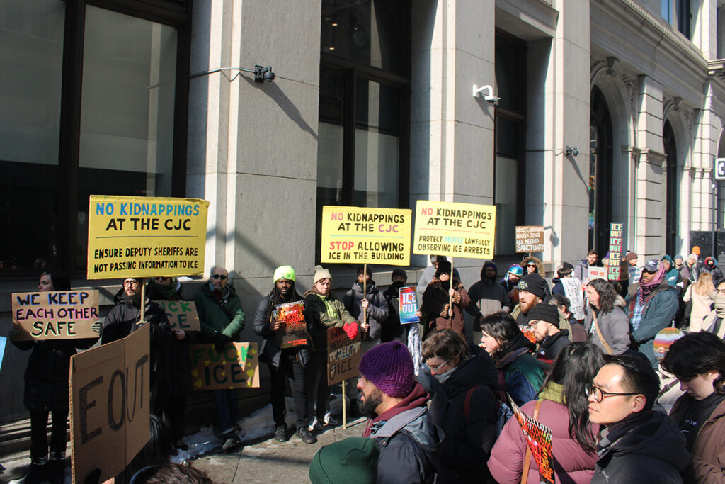 Protesters hold up handmade signs outside the Criminal Justice Center