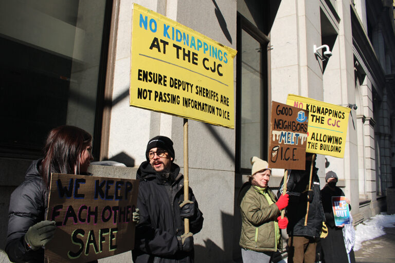 Protesters hold up handmade signs outside the Criminal Justice Center