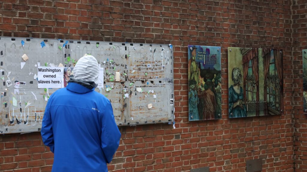 presidents-house-celebration-c-sharber-2026-02-19-01 A visitor reads the text on the panels on display
