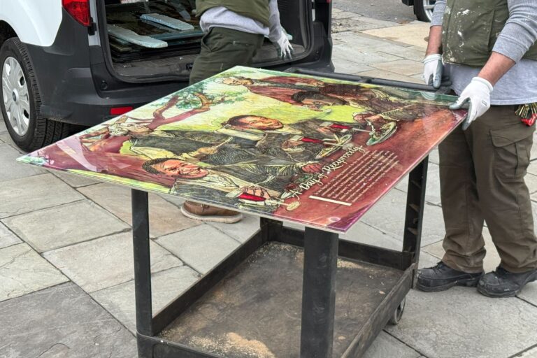 Workers restore panels to the slavery exhibits at the President's House Site on Independence Mall