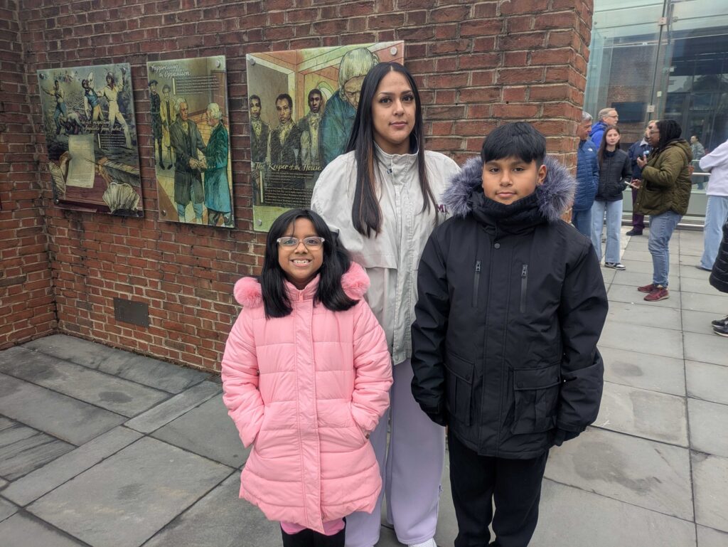 Jasmine Gutierrez posing with her two children at the exhibit